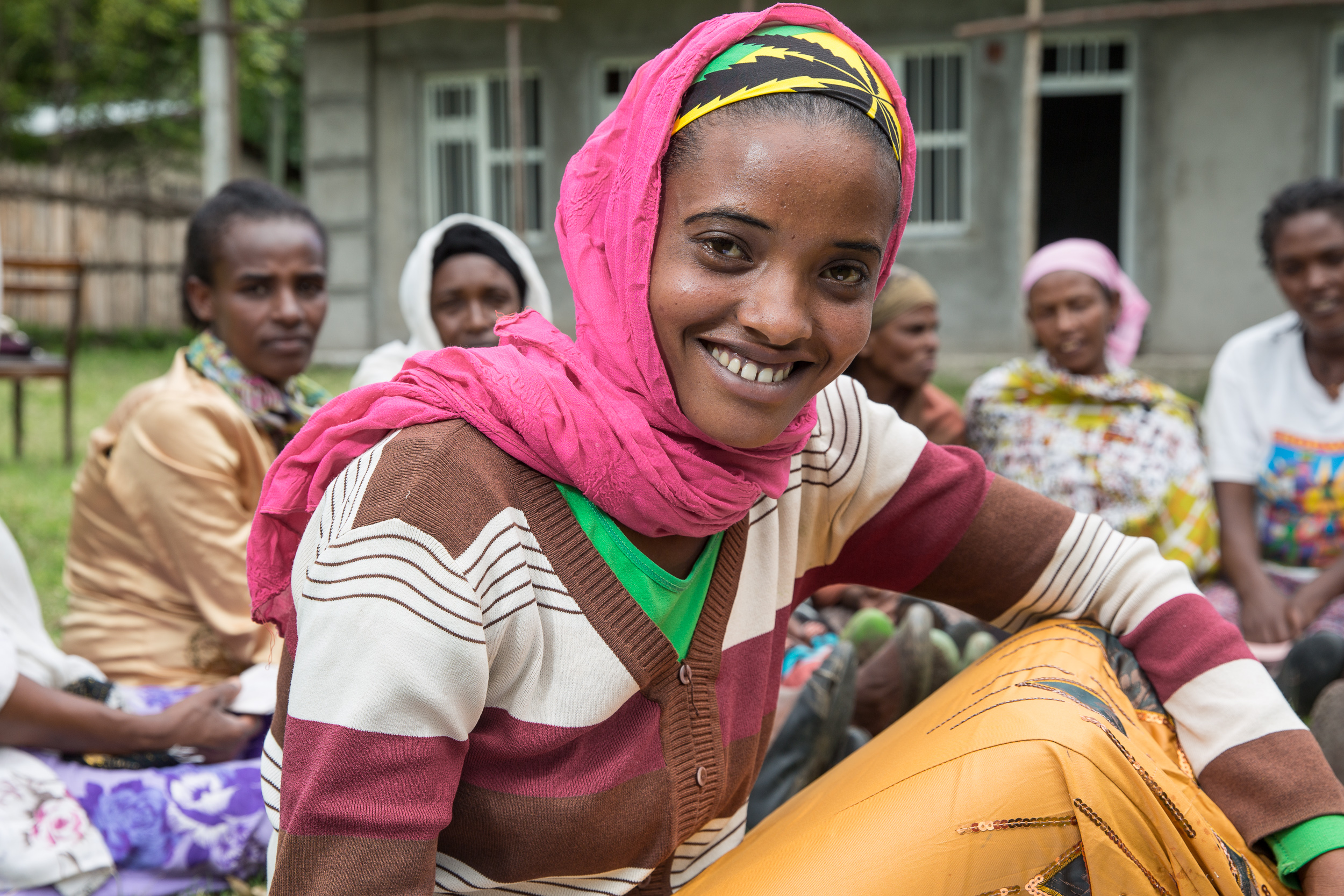 Young Ethiopian woman looking straight into the camera. In the background are several women.