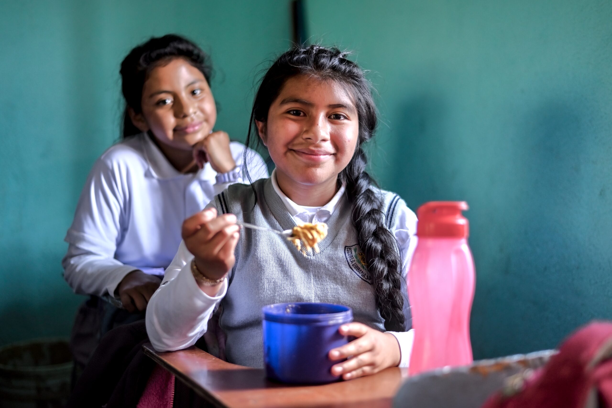 Young girl eating a school meal in a Guatemala classroom