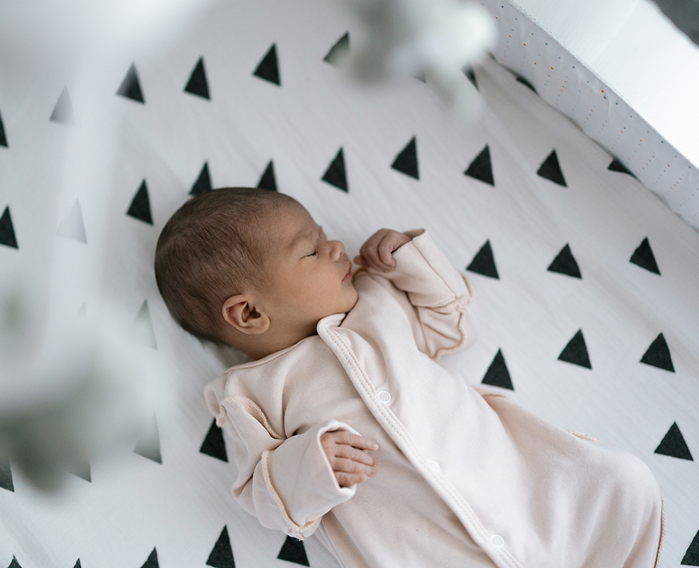 newborn-baby-sleeping-peacefully-modern-crib-with-geometric-patterned-bedding2