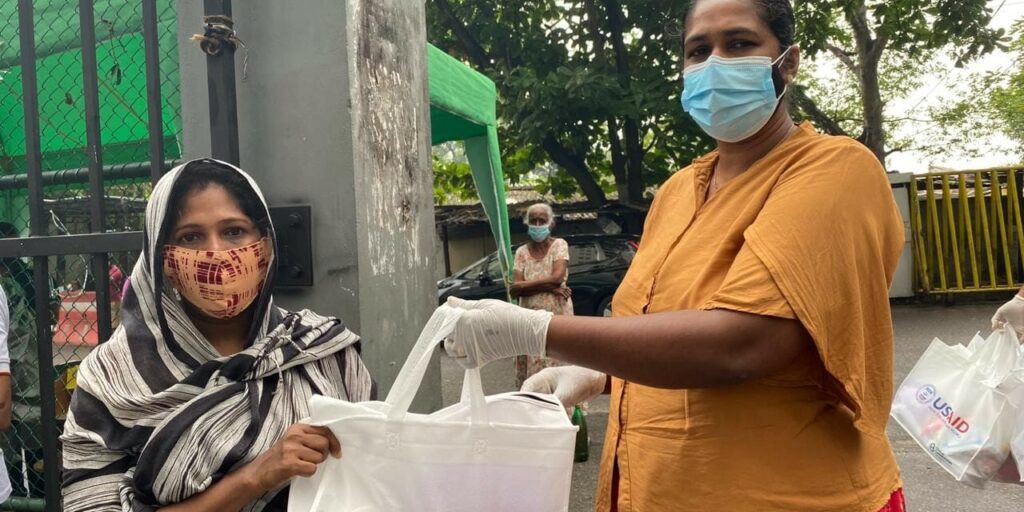 A-CMC-official-hands-over-a-USAID-donated-hygiene-pack-to-a-resident-at-Modara-flats