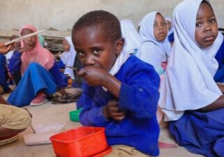 Student in Tanzania eating a school meal